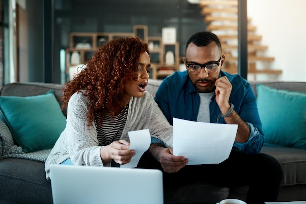 Faites des papiers de facture frustrés ou couple avec des questions documents financiers ou budget du ménage ordinateur portable financier ou des gens inquiets parlant de factures doute ou dette avec la récession impôts ou l'inflation