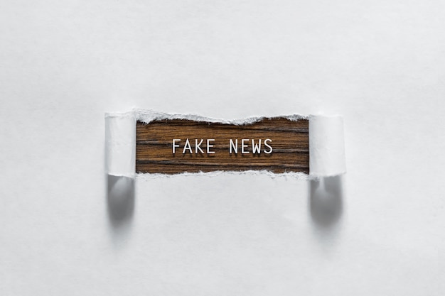 Fake News - une inscription dans un papier blanc déchiré