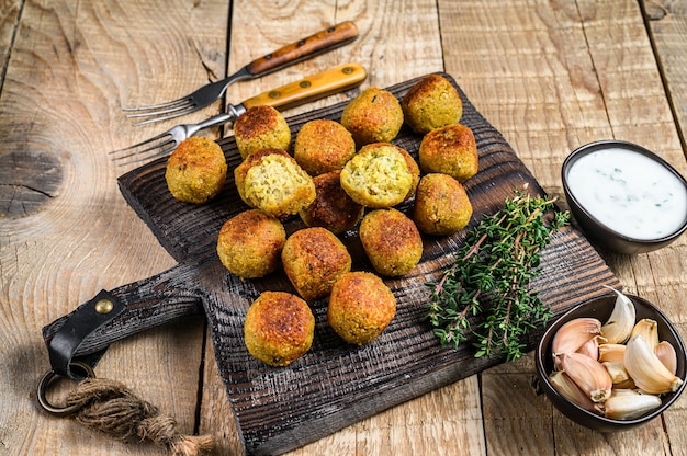 Falafel de pois chiches avec sauce tzatziki sur une planche de bois.