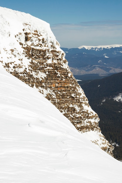 Falaise raide d'hiver sur paysage de montagne