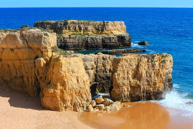 Falaises jaunes sur la plage de sable. Vue de dessus de la côte rocheuse de l'Atlantique d'été (périphérie d'Albufeira, Algarve, Portugal).