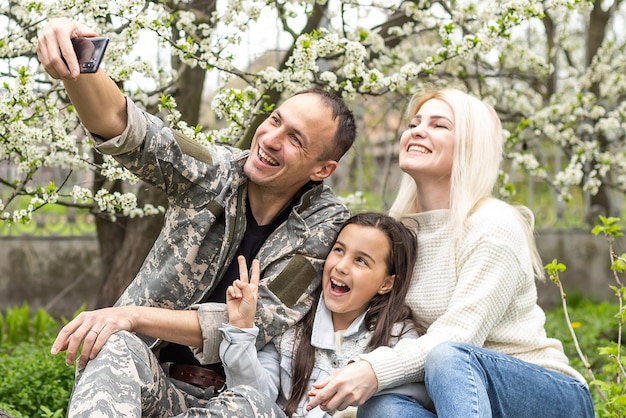 Famille accueillant son mari à la maison en congé militaire.