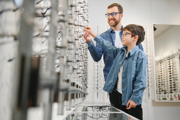 La famille achète des lunettes Père en chemise bleue