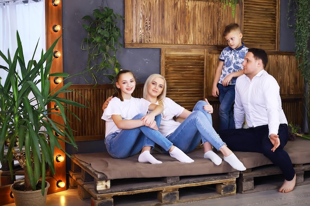 Famille active drôle de jeunes parents adultes et de petits enfants mignons jouant ensemble dans le salon intérieur enfants s'amusant à la maison