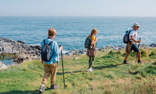 Photo famille adulte en randonnée le long de la côte