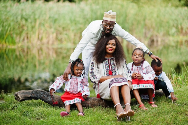 Famille africaine en vêtements traditionnels au parc.