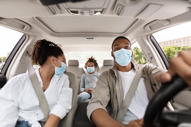 Famille afro-américaine assise dans une voiture portant un masque facial