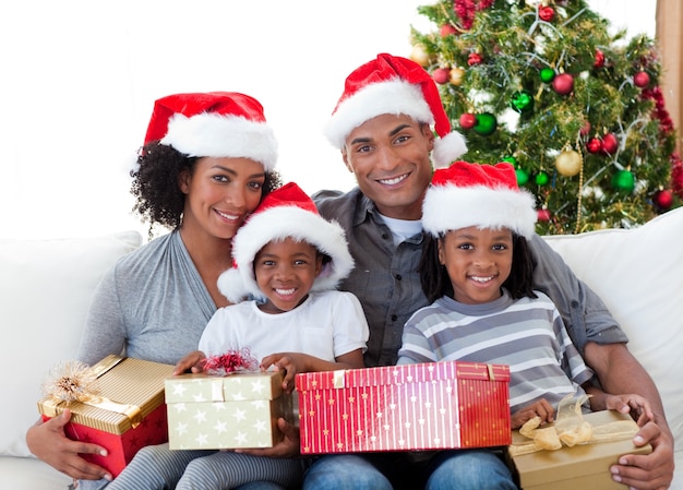 Famille afro-américaine tenant des cadeaux de Noël