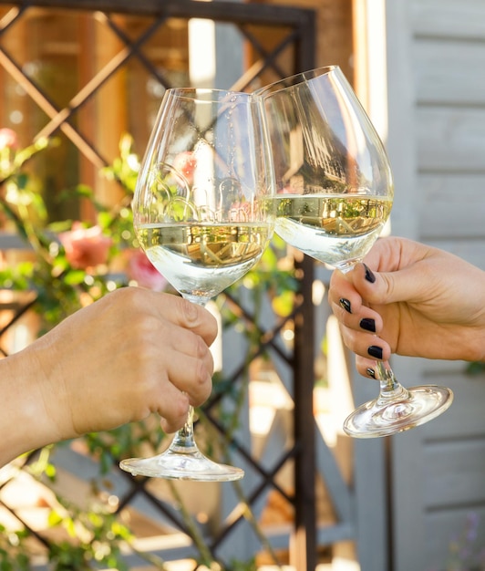 Famille d'âges différents, les gens célèbrent joyeusement à l'extérieur avec des verres de vin blanc proclament un toast