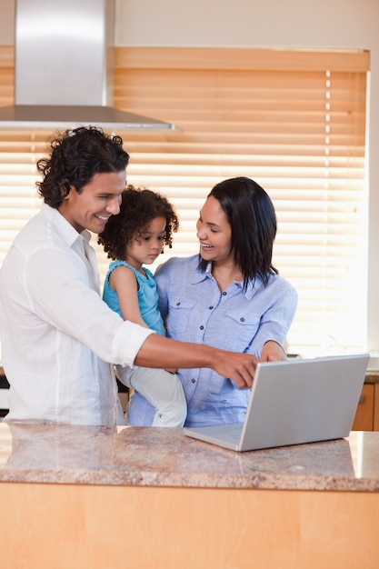 Famille à l&#39;aide d&#39;ordinateur portable dans la cuisine ensemble