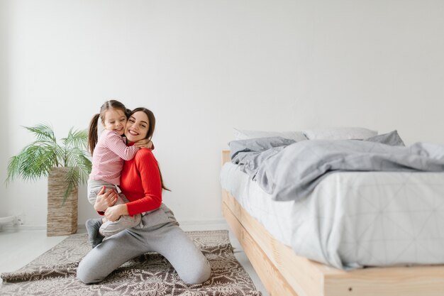 Famille aimante heureuse. Mère et sa fille fille enfant jouant et étreignant.