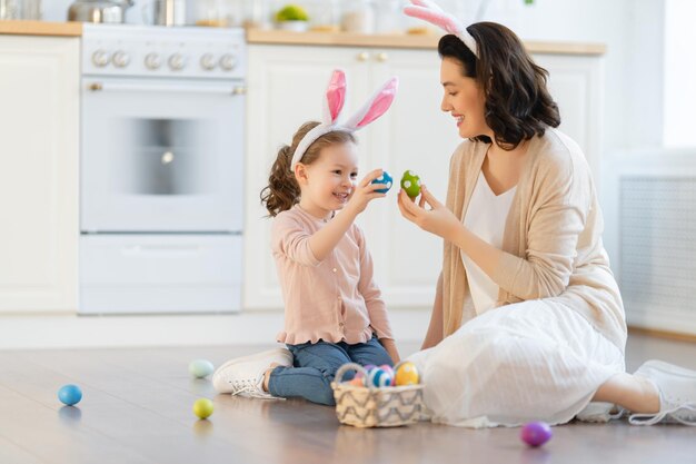 Une famille aimante et heureuse prépare la boulangerie ensemble. La mère et la fille préparent des biscuits et s'amusent dans la cuisine. Fille donnant un bouquet de fleurs à maman.