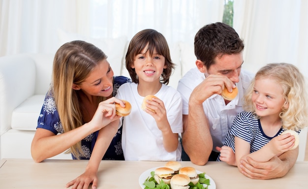 Famille aimante manger des hamburgers dans le salon