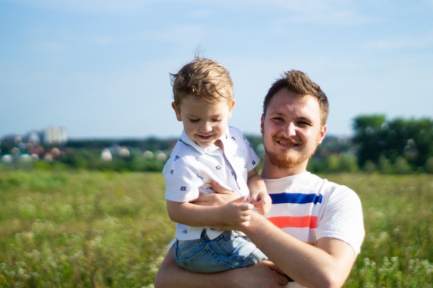 Famille aimante. Père et son fils bébé garçon jouant et étreignant à l'extérieur. Heureux papa et fils à l'extérieur. Concept de la fête des pères.