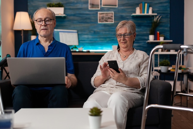 Famille aînée utilisant des appareils de technologie moderne