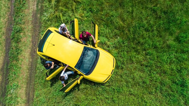 Famille et amis voyagent en voiture en vacances parents et enfants s'amusent en voyage de vacances vue aérienne