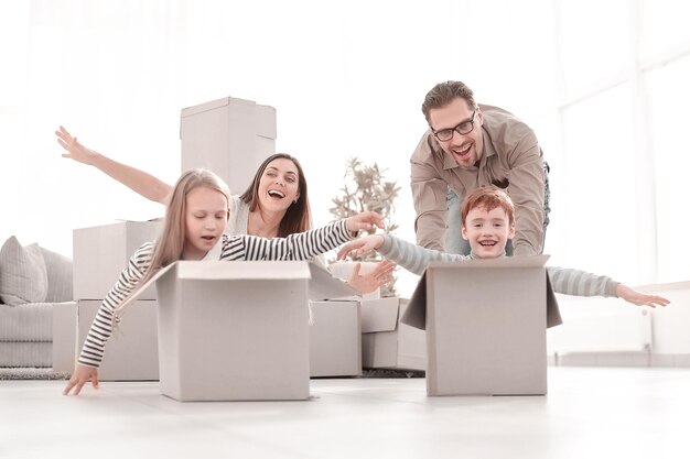 Famille amusante utilisant les boîtes pour jouer dans le nouvel appartement photo avec espace de copie