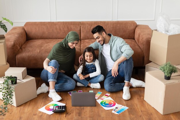 Famille arabe utilisant un ordinateur dans son nouvel appartement