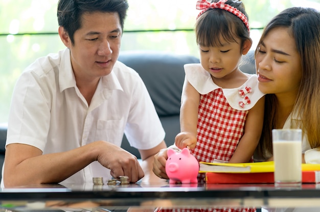 Famille asiatique économiser de l'argent dans la tirelire. Économiser de l'argent