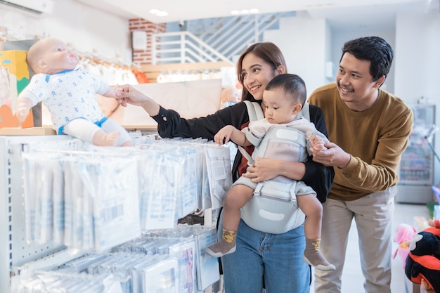 Famille asiatique avec enfant achetant un produit pour bébé au centre commercial