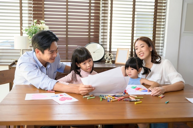 Famille asiatique avec enfants Dessin et peinture sur table dans la salle de jeux à la maison Jeu éducatif