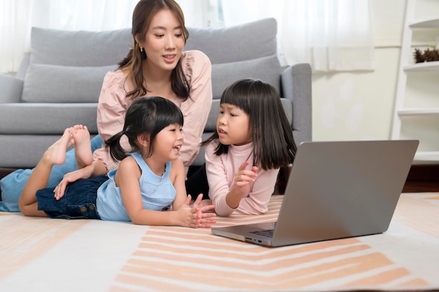 Famille asiatique avec enfants utilisant un ordinateur portable à la maison