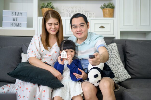 Une famille asiatique heureuse devant la télévision passe du temps ensemble à la maison le week-end