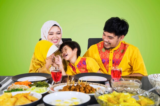 Famille asiatique riant à la table à manger