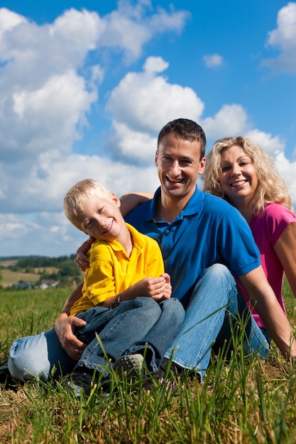 famille assis dans l&#39;herbe sur Prairie