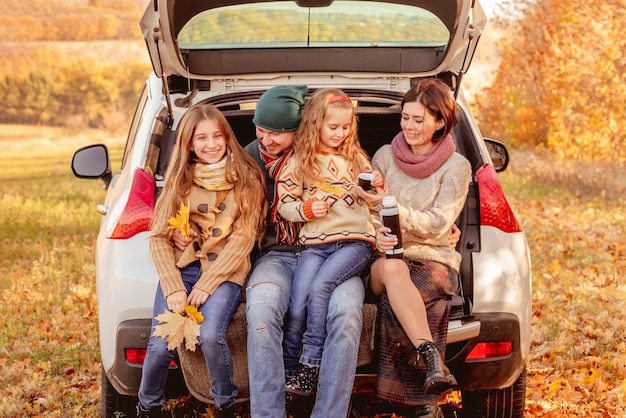 Photo famille assise dans le coffre de la voiture