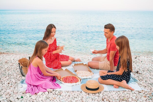 Photo une famille assise à la plage.