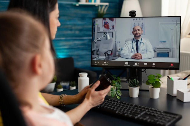 La famille attend les conseils médicaux d'un médecin thérapeute à distance discutant du diagnostic de maladie lors d'une conférence de réunion par vidéoconférence en ligne. Téléconférence sur ordinateur. Consultation en télétravail à distance