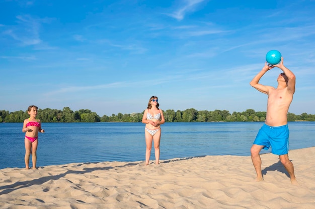 Famille au bord de la rivière jouant au beach-volley