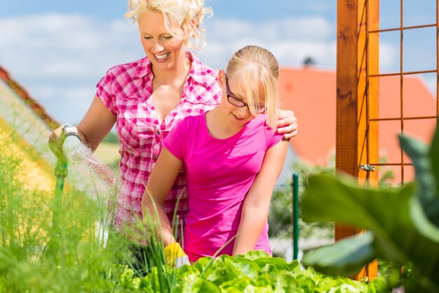 Famille au jardinage devant leur maison