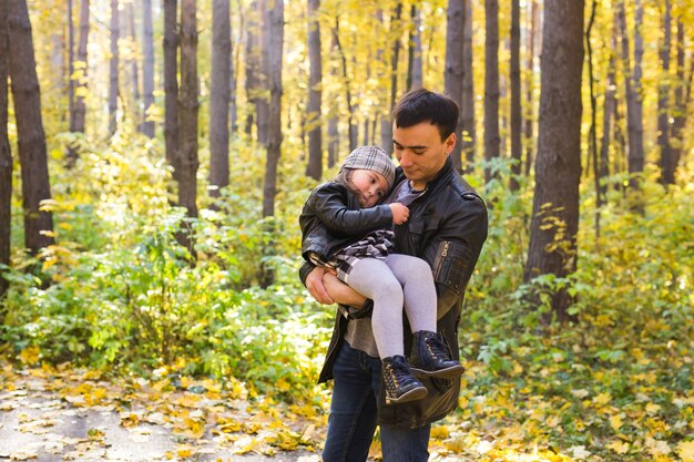 Famille, automne, concept de personnes - père et fille marchant dans le parc d'automne.