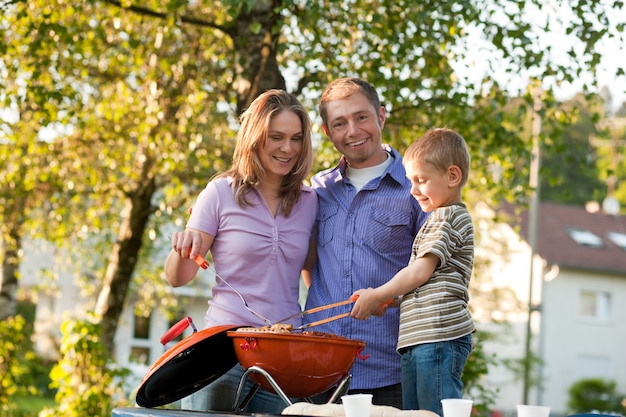 Famille ayant un barbecue dans leur jardin