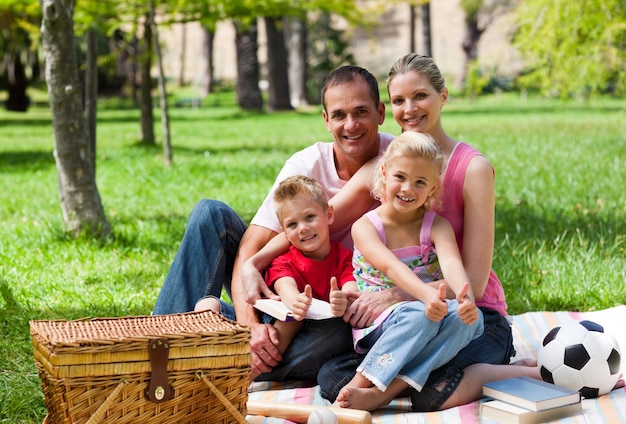 Famille ayant un pique-nique en souriant à la caméra