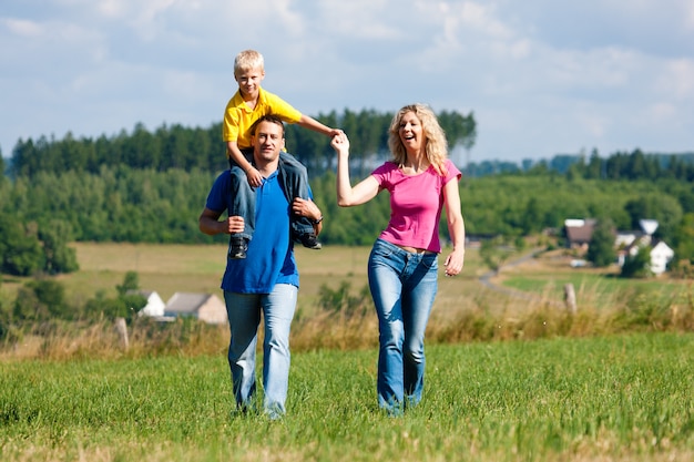 Famille ayant une promenade sur le pré