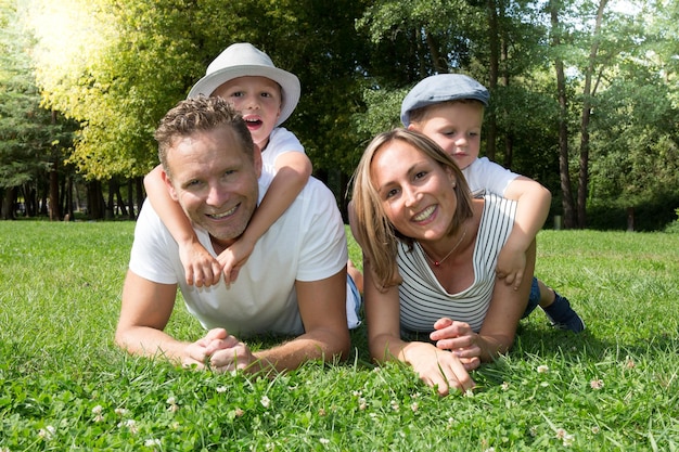 Famille blonde jouant dans le parc sur l'herbe