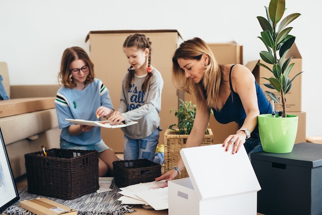 Famille avec des boîtes en carton dans une nouvelle maison au jour du déménagement.