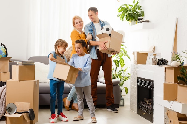 Famille avec des boîtes en carton debout dans la rangée à la maison