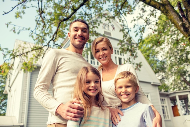 famille, bonheur, génération, maison et concept de personnes - famille heureuse debout devant la maison à l'extérieur