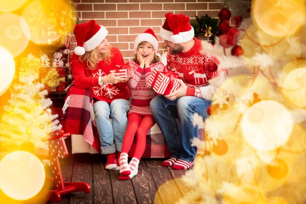 Famille avec cadeau de Noël. Mère; père et enfant s'amusant ensemble. Les gens jouent à la maison