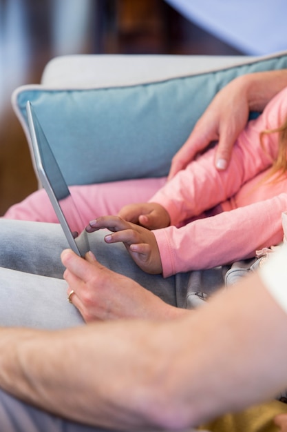 Famille sur le canapé ensemble à l&#39;aide de tablet pc