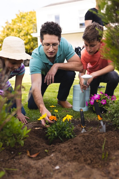 Photo une famille caucasienne passe du temps ensemble dans le jardin, plantant. passer du temps en famille à l'extérieur, jardin, jardinage, concept.