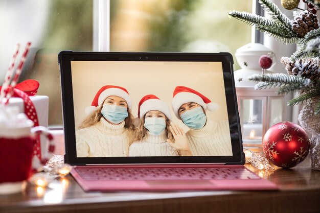 Famille célébrant les vacances de Noël en ligne par chat vidéo en quarantaine. Concept de verrouillage de la maison. Fête de Noël pendant la pandémie de coronavirus COVID 19