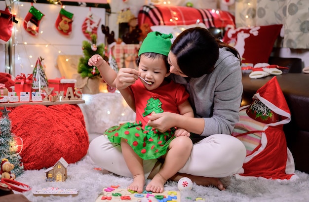 La famille célèbre Noël et la bonne année à la maison. Mode de vie des mamans et des enfants pendant les vacances de fin d'année.