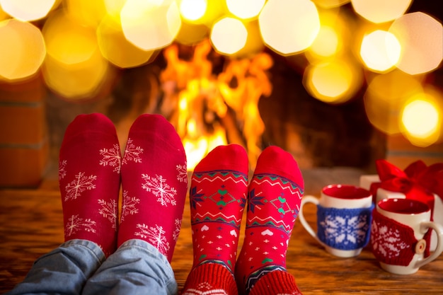 Famille en chaussettes de Noël près de la cheminée