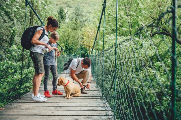 Famille avec chien en randonnée dans la forêt