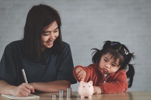 Famille Économiser de l'argent Une femme asiatique et sa fille prévoient de dépenser l'avenir dans des finances sérieuses et d'économiser la famille et le concept financier